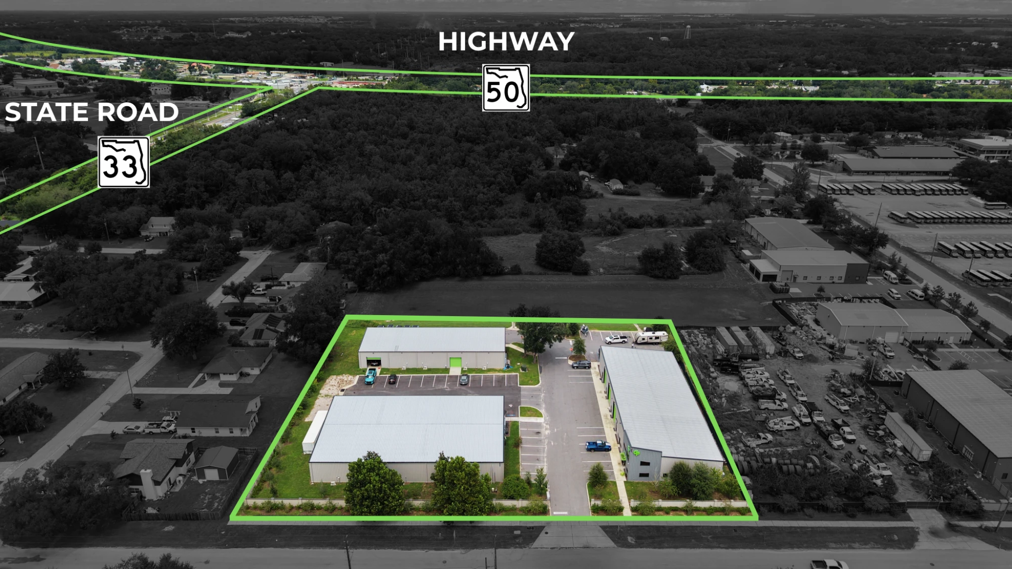 Aerial of a Central Florida commercial property with the parcel boundary outlined in green and State Road 33 and Highway 50 labeled on the image