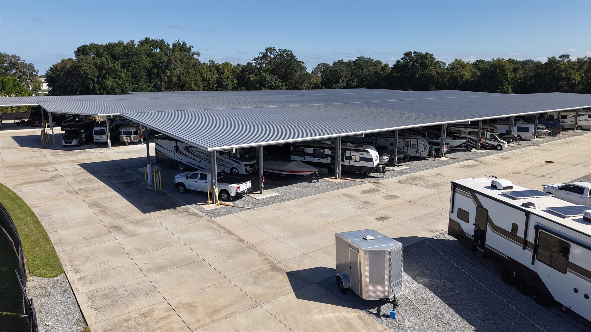 Drone photo of covered RV and boat storage canopies with wide paved drive aisles