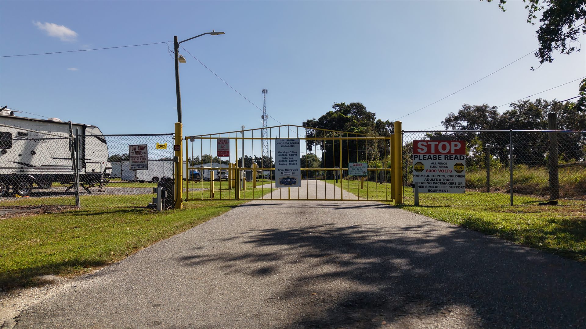 Photo of the gated keypad entrance and security signage at a self storage and RV storage facility